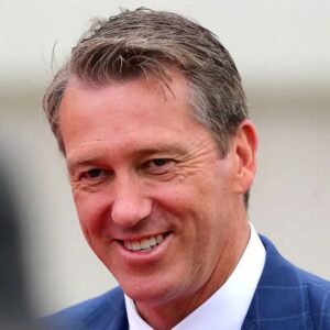 Smiling man in a blue suit jacket and white shirt, looking slightly to the left.