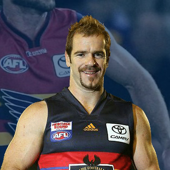 Portrait of a smiling AFL player in a black-and-red club jersey with sponsor patches on the chest and shoulder.